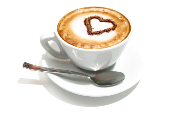 Белая чашка с капучино с сердцем из корицы на пене 