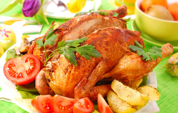 Запеченная курица на столе со свежими помидорами