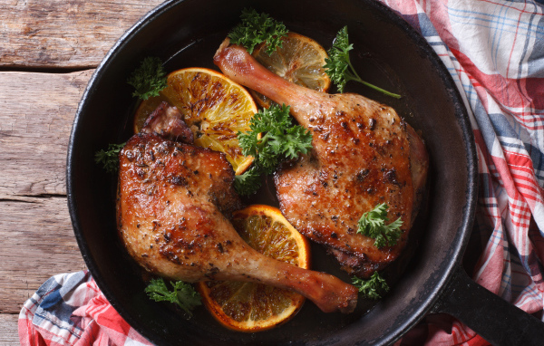Куриные окорочка в сковороде с кольцами апельсина и петрушкой
