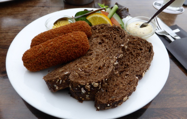 Два куска черного хлеба на тарелке с котлетами