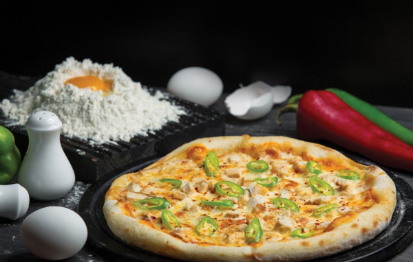 Пицца на столе с яйцами и перцем