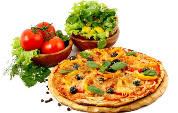Пицца на столе с овощами и зеленью на белом фоне