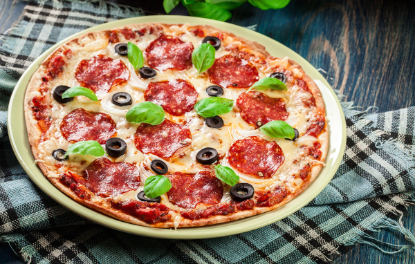 Пицца с сыром и салями на столе 