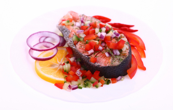 Кусок красной рыбы с овощами на белом фоне