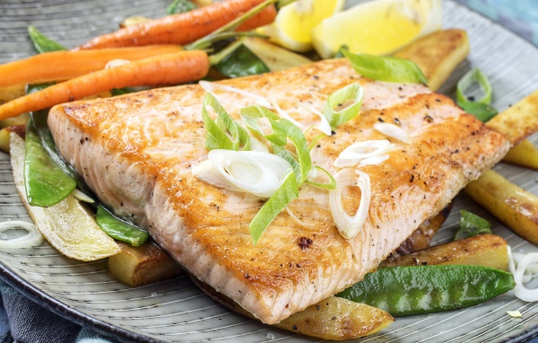 Запеченная красная рыба с овощами на тарелке