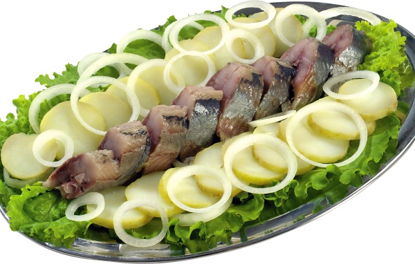 Сельдь с вареным картофелем, луком и листьями салата на белом фоне