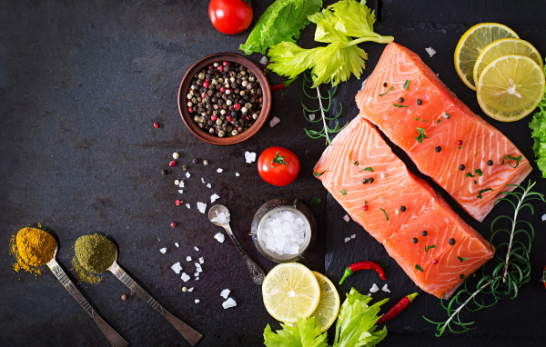 Куски красной рыбы на столе с лимоном и специями