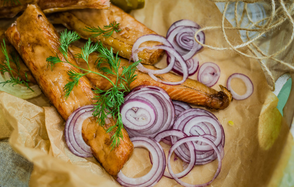 Копченое филе рыбы на бумаге с луком