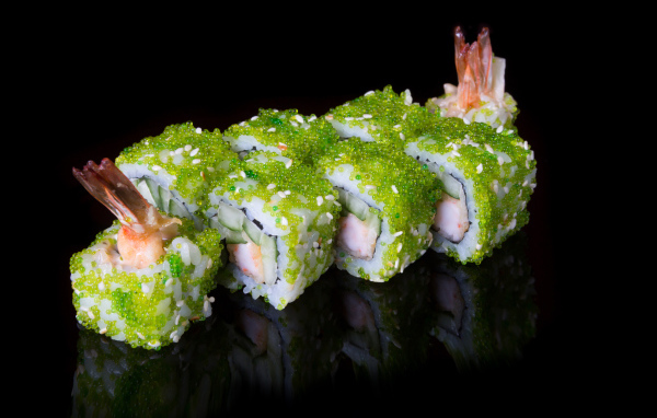 Суши с икрой и креветками на черном фоне