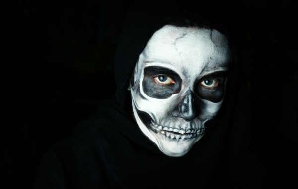 Girl with a mask with makeup on her face on a black background
