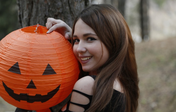 Улыбающаяся девушка с декором на праздник Хэллоуин