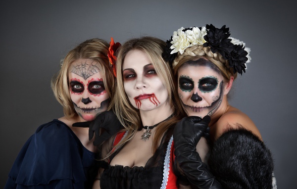 Три девушки с масками и в костюмах на Хэллоуин 