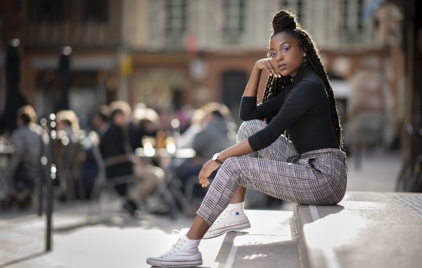 Красивая темнокожая девушка сидит на ступеньках