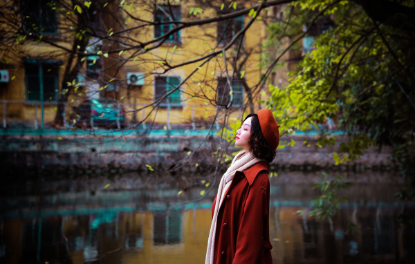 Девушка азиатка в красном пальто у воды