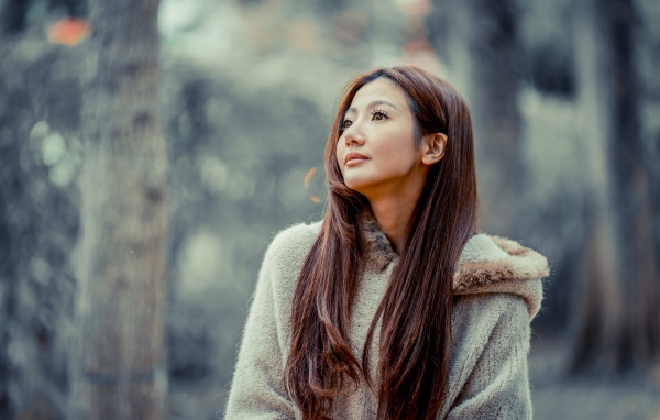 Длинноволосая девушка азиатка смотрит в сторону