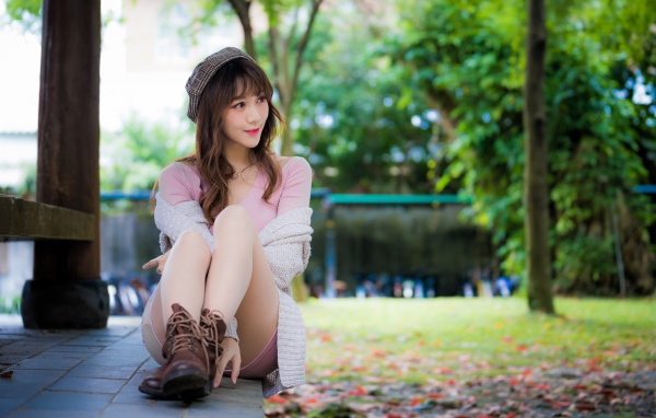 Красивая девушка азиатка сидит на земле 