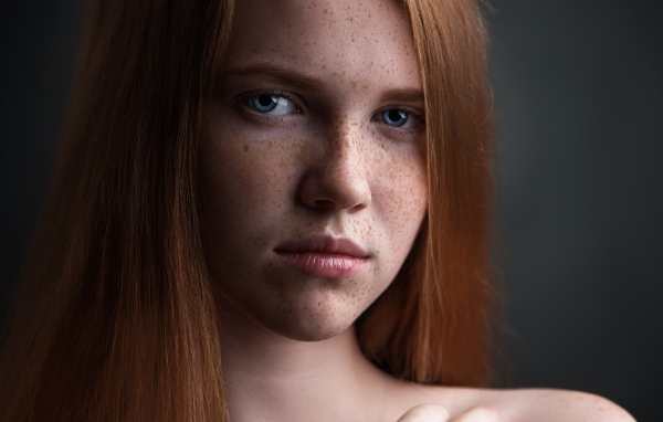 Красивая голубоглазая рыжеволосая девушка с веснушками