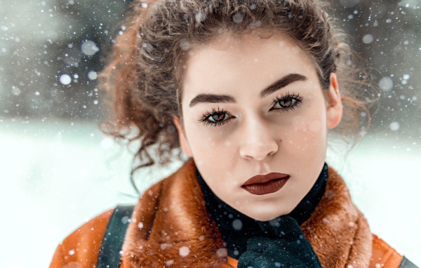 Красивая кареглазая девушка стоит на улице зимой