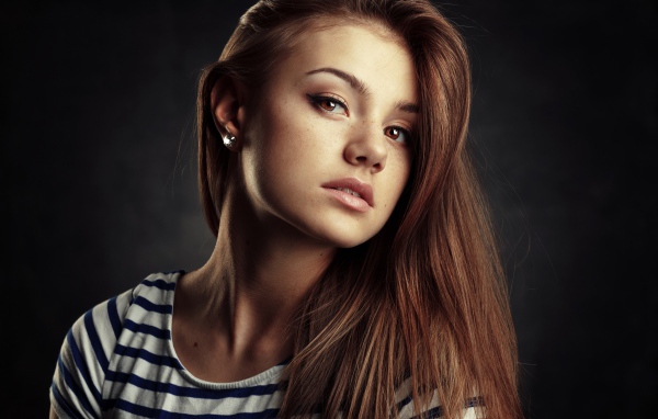 Красивая кареглазая девушка с русыми волосами на сером фоне