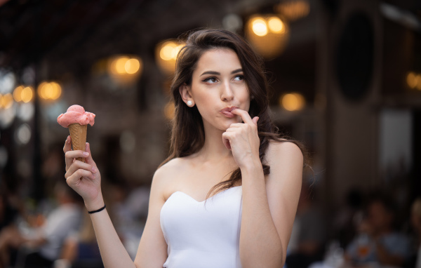 Красивая девушка шатенка с мороженым в руке