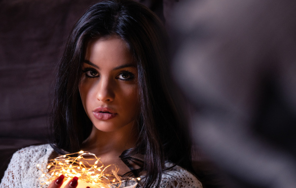 Красивая брюнетка с гирляндой в руках