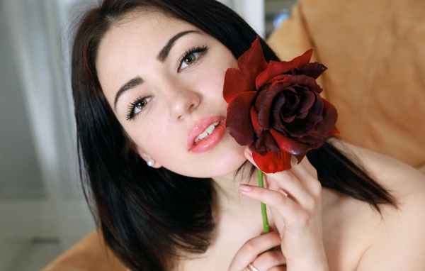 Красивая брюнетка с красной розой в руке