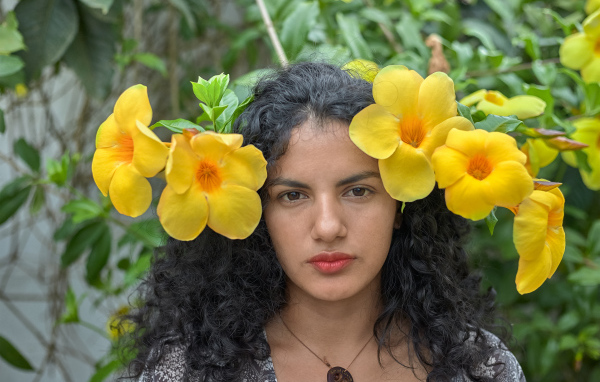 Красивая брюнетка с большими желтыми цветами в волосах 