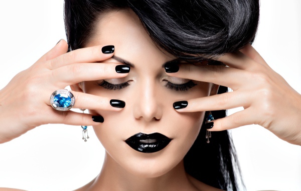 Красивая брюнетка с черным макияжем на белом фоне