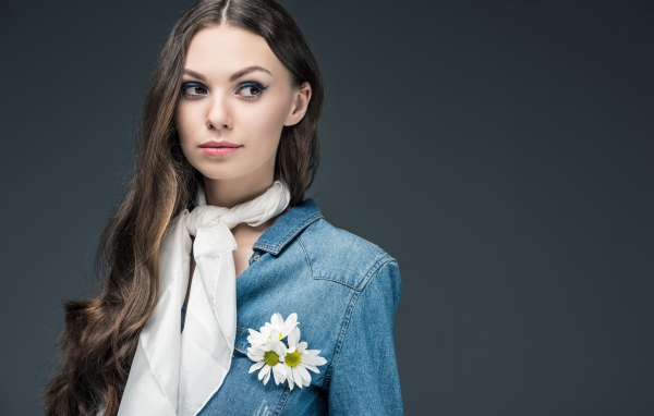 Красивая девушка в джинсовой куртке с шарфом на шее 