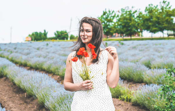 Красивая девушка в платье с букетом маков