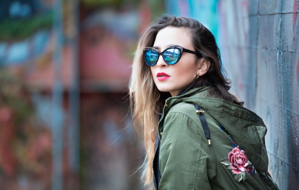 Красивая девушка в куртке и солнечных очках