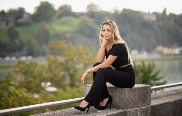Красивая девушка в черном сидит