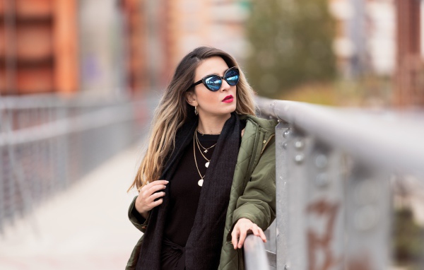 Красивая девушка в солнечных очках на мосту