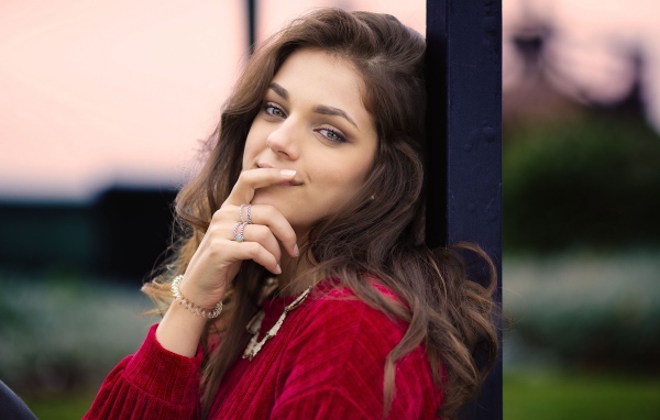 Красивая длинноволосая шатенка с рукой у лица