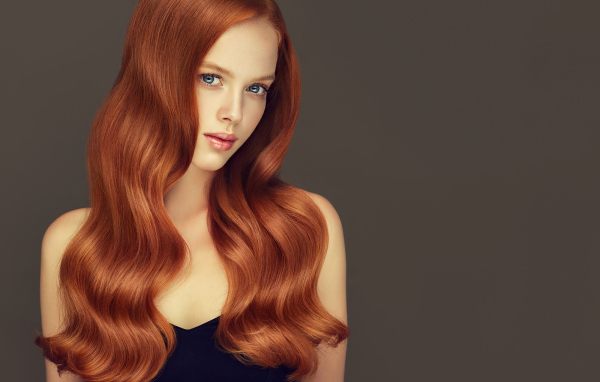 Красивая рыжеволосая голубоглазая девушка на сером фоне