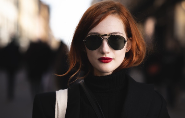 Красивая рыжеволосая девушка в темных очках