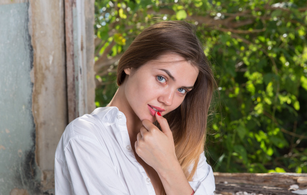 Красивая нежная девушка с серыми глазами с пальцем у рта
