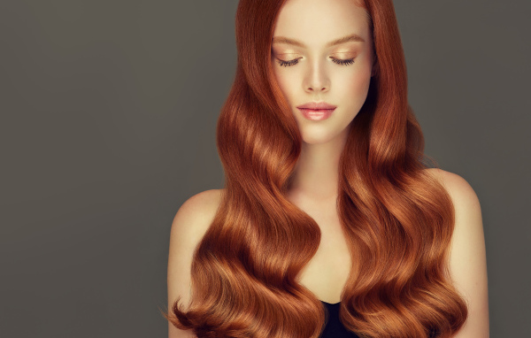 Красивая нежная рыжеволосая девушка на сером фоне