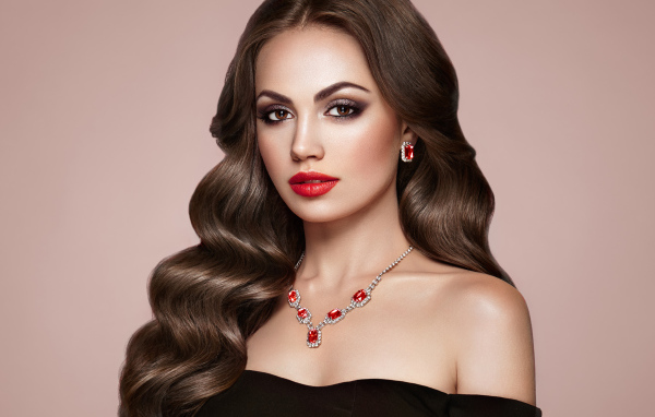 Яркая красивая девушка с украшениями на розовом фоне