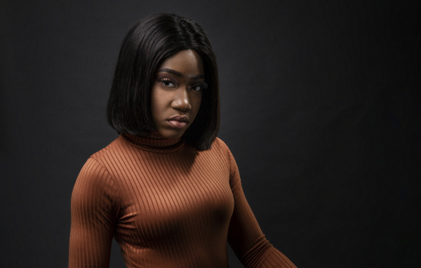 Темнокожая девушка с короткой стрижкой на сером фоне