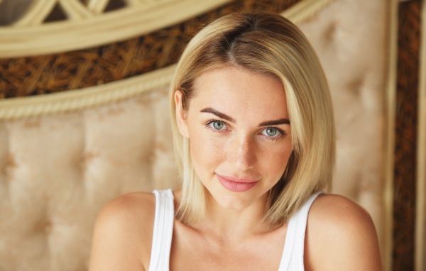 Нежная блондинка с зелеными глазами в белой майке