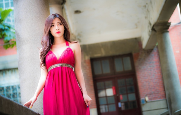 Девушка в красивом розовом платье у здания