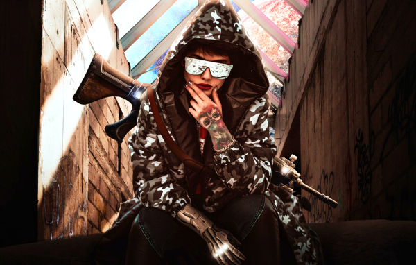 Девушка с оружием в худи и очках 