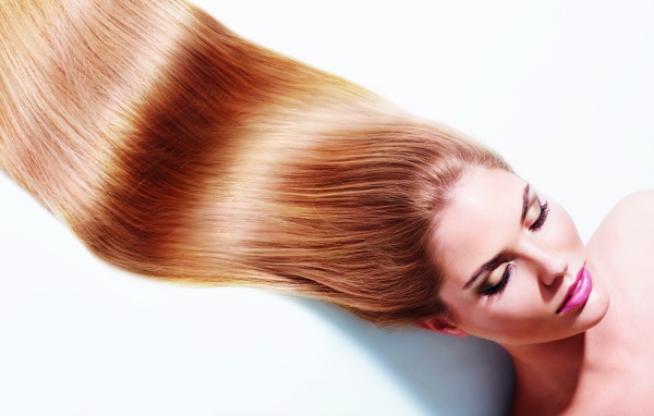 Длинноволосая шатенка с закрытыми глазами на белом фоне