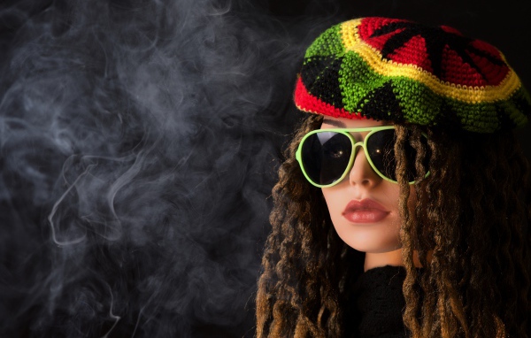 Девушка растаманка в черных очках в дыму