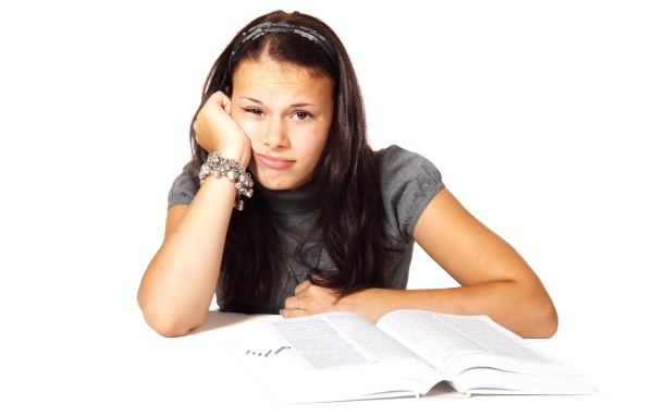 Грустная девушка читает книгу на белом фоне