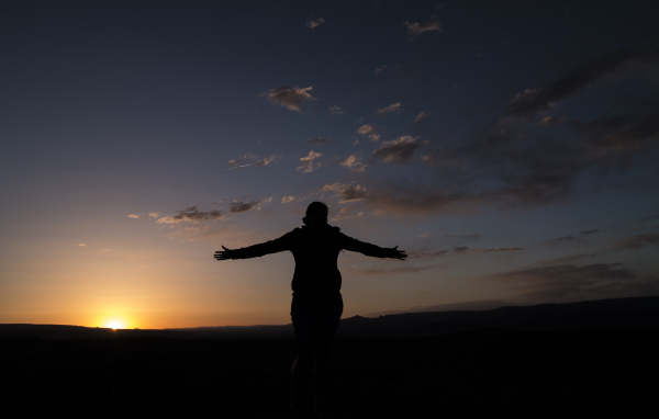 Силуэт девушки на фоне неба на закате