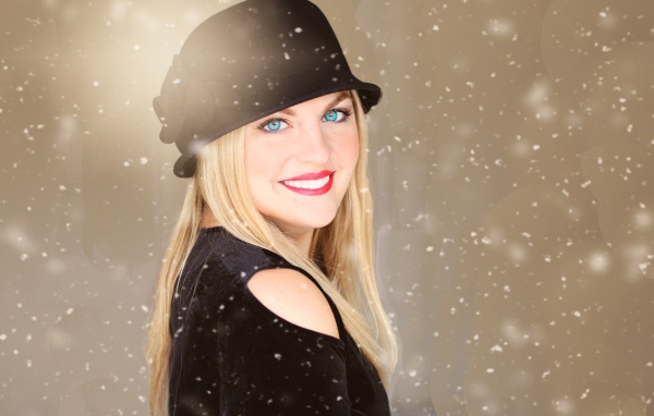 Улыбающаяся голубоглазая девушка в черной шляпе