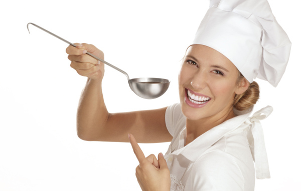Улыбающаяся девушка в костюме повара с половником