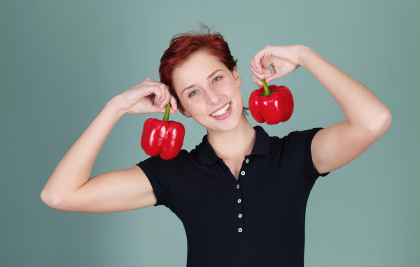 Улыбающаяся девушка с болгарским перцем в руках
